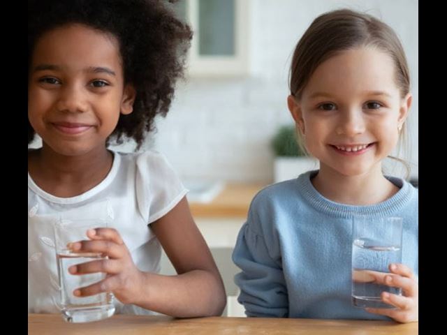 Two kids with glasses of drinking water tested with at-home testing kits from 2023ȫ 